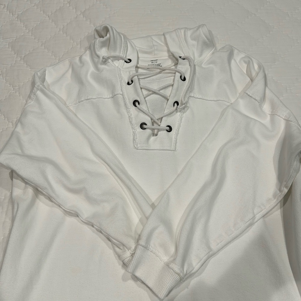 White oversized hooded sweatshirt with metal brad and rope ties.